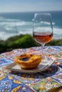 Portugal`s traditional food and drink, glass of porto wine or muscatel de setubal and sweet dessert Pastel de nata egg custard