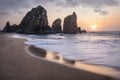 Portugal Ursa Beach. Beautiful sea stacks rocks in sunset light. White atlantic ocean waves on empty sandy beach Royalty Free Stock Photo