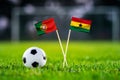 Portugal vs. Ghana, Stadium 974, Football match wallpaper, Handmade national flags and soccer ball on green grass. Football Royalty Free Stock Photo