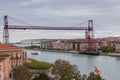 Biscay bridge flying with gondola and boat on river Nervion, toned. Portugalete landmark. Famous bridge called Puente de Vizcaya.