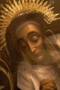 Statue of Virgin Maria with tears through glass filtered. Sculpture of Saint Maria with tears behind glass. Sadness and grief.