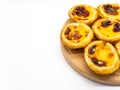 Portughese dessert pasteis de nata on wooden plate on white background with copy space Royalty Free Stock Photo