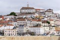 Portuguese city with white buildings and red-tiled roofs on a hill