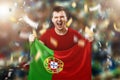 A Portuguese fan, a fan of a man holding the national flag of Portugal in his hands. Soccer fan in the stadium. Mixed media Royalty Free Stock Photo