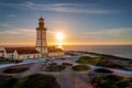 Portuguese lighthouse on cape Espichel at sunset, sea horizon and sun