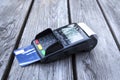 POS terminal, hand swiping credit card, payment with NFC tecnology on wooden background