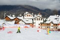 Posa Khutor, Sochi, Russia, January, 26, 2018. Instructor and little boy skiing on the child`s training slope in the background of