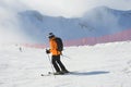 Posa Khutor, Sochi, Russia, January, 28, 2018.The skier in orange jacket down from ski slope `Triton` from Rosa Peak in condition