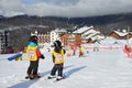 Posa Khutor, Sochi, Russia, January, 26, 2018. Two little boys skiing on the child`s training slope in the background of Olympic