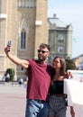 They pose with a smile with shopping bags and take pictures with a mobile phone.