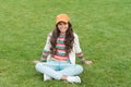 Posing for photo. beautiful student teen girl in park. cute smiling confident schoolgirl relax on green grass. happy