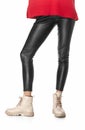 Slim legs of young girl in black leggings and boots isolated on white background Royalty Free Stock Photo