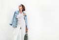 Posing woman in elegant white color outfit with oversize denim j