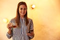 Posing woman with tea and cellphone Royalty Free Stock Photo