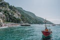 Positano, Italy - August 14, 2019: Man in red boat in front of Positano beach, Amalfi Coast