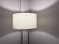 minimalist close-up photo of a modern floor lamp with a warm white fabric lampshade Royalty Free Stock Photo