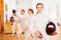 Positive active young female fencer standing at fencing workout
