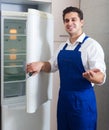 Handyman repairing refrigerator in kitchen Royalty Free Stock Photo