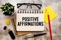 positive affirmations - file cabinet label, bronze holder against grunge and scratched wood.