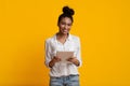 Positive African American Girl Holding Digital Tablet, Posing Over Yellow Background