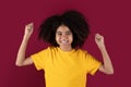 Positive african american girl raising fists up and smiling Royalty Free Stock Photo
