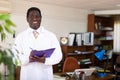 Positive african american male doctor writes important notes on a folder of documents