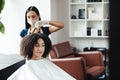 Positive african american woman enjoying hairstyling at reopened beauty salon