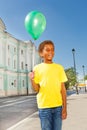 Positive African boy with green flying balloon