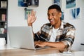 Positive african man gesturing while having video call via laptop at home Royalty Free Stock Photo