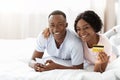 Positive african man and woman with credit card and smartphone Royalty Free Stock Photo