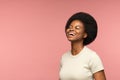 Cheerful african woman happy laughing over pink wall. Delightful young girl smiling with closed eyes