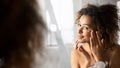 Positive Afro Girl Applying Eye Cream Preventing Wrinkles In Bathroom Royalty Free Stock Photo