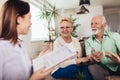 Aged couple consulting with insurance agent