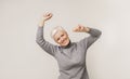 Positive aged lady dancing over light studio background