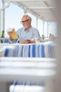 Positive aged man sitting at the table