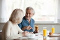 Positive aged spouses eating breakfast talking sitting in the kitchen Royalty Free Stock Photo