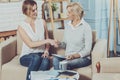 Positive aged woman greeting her financial advisor