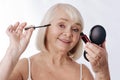 Positive aged woman using mascara Royalty Free Stock Photo