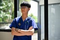 A positive Asian male doctor stands in the hospital corridor with his arms crossed Royalty Free Stock Photo