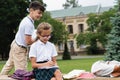 Positive asian schoolkid looking at friend