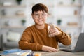 Positive asian teenager holding glass of water while studying Royalty Free Stock Photo