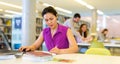 Asian woman working with laptop and books on science project in library Royalty Free Stock Photo