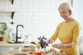 Positive woman preparing bruschetta in kitchen