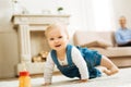 Positive lovely baby looking happy while playing on the carpet Royalty Free Stock Photo