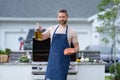 positive bbq man with salmon fish outdoor. bbq man with salmon fish in apron.