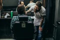 Positive bearded barber smiling and carefully brushing beard of client Royalty Free Stock Photo