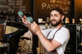 positive bearded barista in apron looking