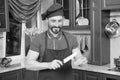 Positive bearded cook cutting pepper using kitchen knife