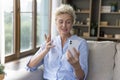 Positive beautiful blonde mature woman speaking on video call Royalty Free Stock Photo