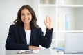 Positive middle aged businesswoman posing at office, waving at camera Royalty Free Stock Photo